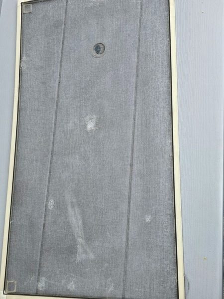 Damaged window screen before repair